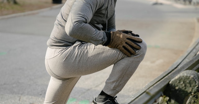 unrecognizable man stretching legs represents health