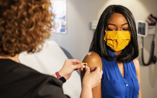 woman getting flu vaccine from her healthcare provider